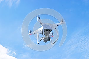 The New Aircraft DJI Phantom 4 pro quadcopter drone with 4K video camera and wireless remote controller flying in the sky. Aerial
