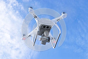 The New Aircraft DJI Phantom 4 pro quadcopter drone with 4K video camera and wireless remote controller flying in the sky. Aerial