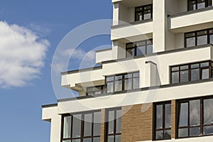 New apartment building with terraced balconies, shiny windows an