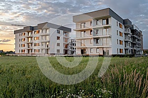 New apartment buildings with balconies on sunset sky background.