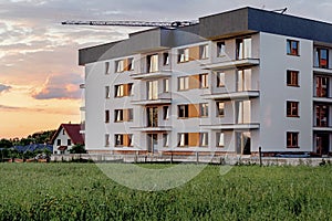 New apartment buildings with balconies on sunset sky background.