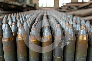 New artillery shells stored in warehouse of weapons factory, metal munition in military storage close-up. Concept of war, photo