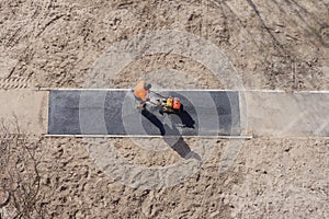 New asphalt construction worker laying road surface on walkway work tarmac. Sidewalk construction road ground work