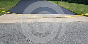 New asphalt driveway and yellow caution tape