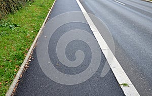 new asphalt pavement along road with a granite raised edge. this surface is not very aesthetic. however, it is easy to clean a