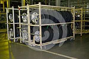 New automobile wheels lie on a rack in assembly shop of automobile plant