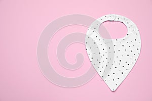 New baby bib on pink background, top view. Space for text