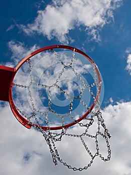 New Basketball hoop shot from below with clouds against blue sky