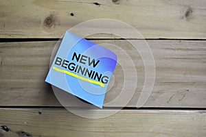 New Beginning text on sticky notes with wooden background