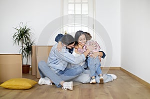 New Beginnings. Happy Family Of Three Embracing At Home On Moving Day