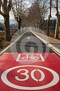 New bicycle path on the road, straight bike lane with red sign