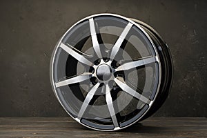 new black alloy wheels on a dark textured black background. wheel for car spare parts auto repair tire shop,