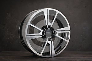 new black alloy wheels on a dark textured black background. wheel for car spare parts auto repair tire shop,