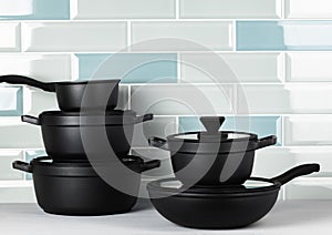 New black cookware against blue tile wall