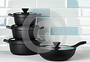 New black cookware against blue tile wall