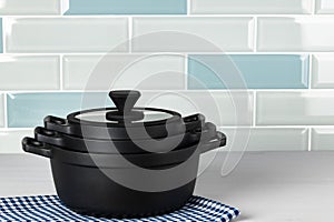 New black cookware against blue tile wall