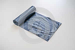 new black trash bag roll on the colorful surface, isolated, care the planet