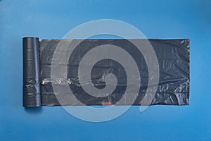 new black trash bag roll on the colorful surface, isolated, care the planet
