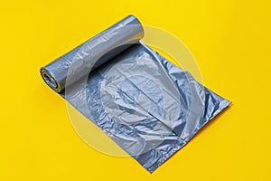 new black trash bag roll on the colorful surface, isolated, care the planet