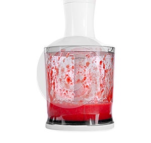 A new blender with mixed strawberries isolated on a white background. A container full of strawberry jam. Sweet and mixed berries.