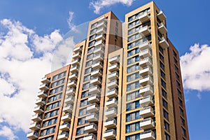 New block of modern apartments with balconies and blue sky