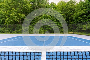 New blue tennis court with white lines and gray out of bounds
