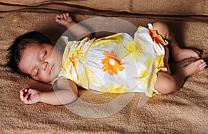 New born asian baby girl sleeping in cute dress