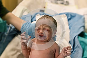 New born baby. baby without clothes and crying on. Nurse holding baby