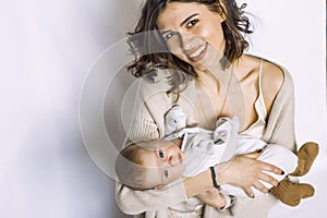 New born baby boy sleeping, smiling on mother`s arm. fashion mother.