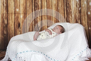 New born baby boy sleeping on a white blanket