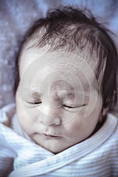 new born baby curled up sleeping on a blanket, multiple expressions