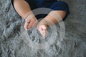 New born baby feet on grey carpet