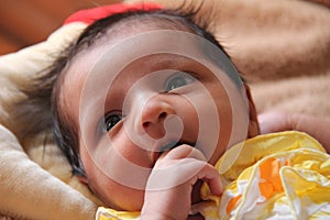 New born baby girl thinking and sucking fingers