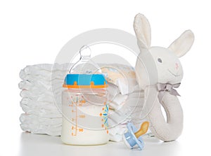 New born child stack of diapers, nipple soother, beanbag bunny