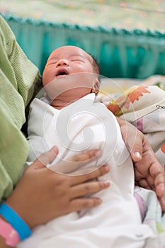 new born infant asleep in the blanket in delivery room