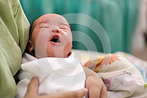 new born infant asleep in the blanket in delivery room