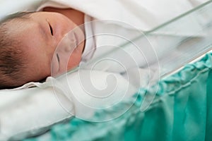 new born infant asleep in the blanket in delivery room