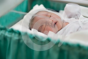 new born infant asleep in the blanket in delivery room