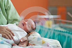 new born infant asleep in the blanket in delivery room