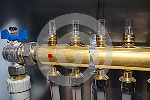 New brass manifold for underfloor heating systems with magnetic rotameters and open blue valve.