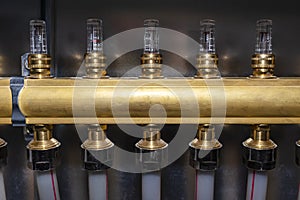 New brass manifold for underfloor heating systems with magnetic rotameters, seen up close.