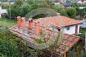 New brick house with red roof tile pattern and modular chimney, plastic windows and rain gutter