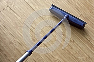 A new broom sweeping a floor.