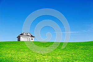 New built house on green meadow under blue sky