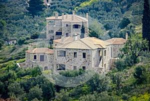 New built luxurious stone house with ceramic roofs surrounded by green nature. Greece.