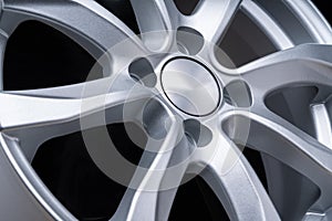 New car alloy wheel, over black background, close up the spokes of the disc