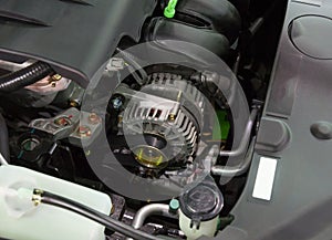 New car alternator installed in the engine compartment of a modern car closeup view