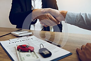 New car buyers and car salesmen are shaking hands to make agreements about car sales