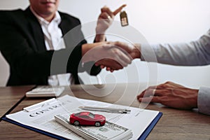 New car buyers and car salesmen are shaking hands to make agreements about car sales photo