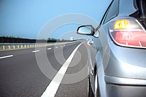 New car driving fast on a road in mountains